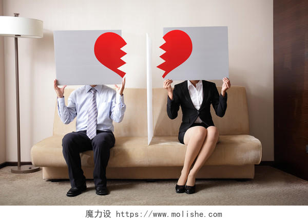 离婚悲伤的年轻夫妇牵着广告牌标志与打破爱的心离婚的概念